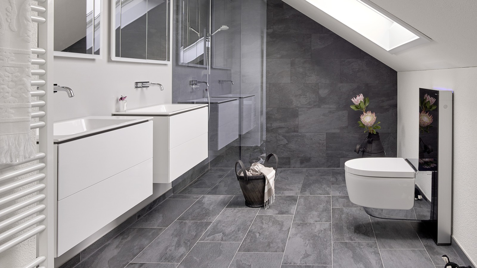 Kupaonica s kosim krovom i proizvodi iz linija kupaonske opreme Geberit ONE i Geberit AquaClean s Monolithom