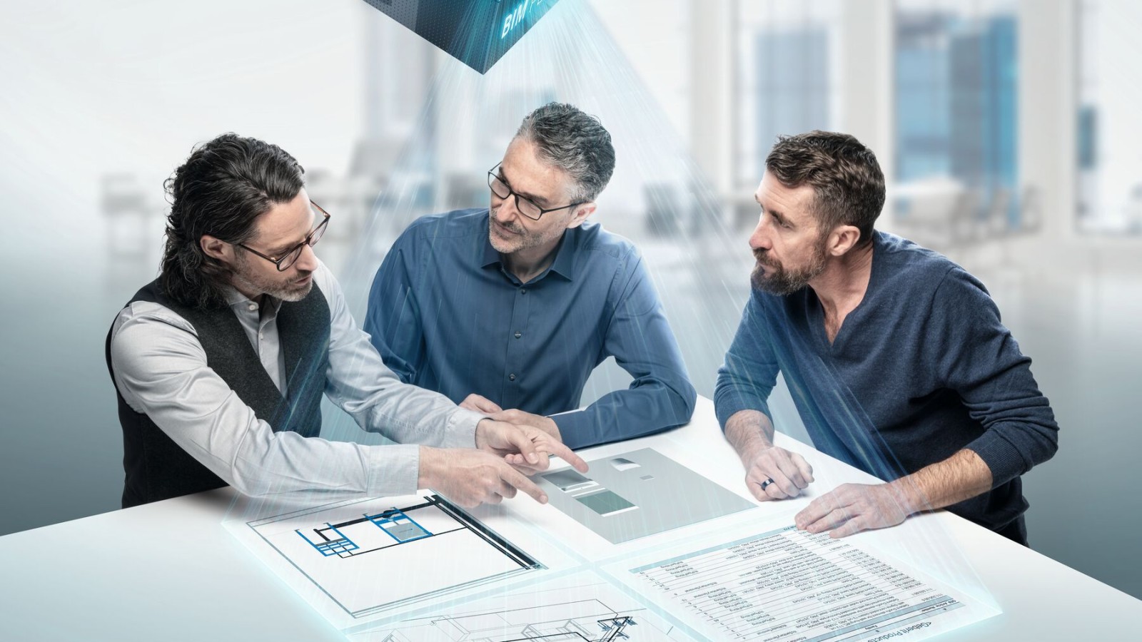 Projektanti udubljeni u razgovor oko stola sa simbolom BIM